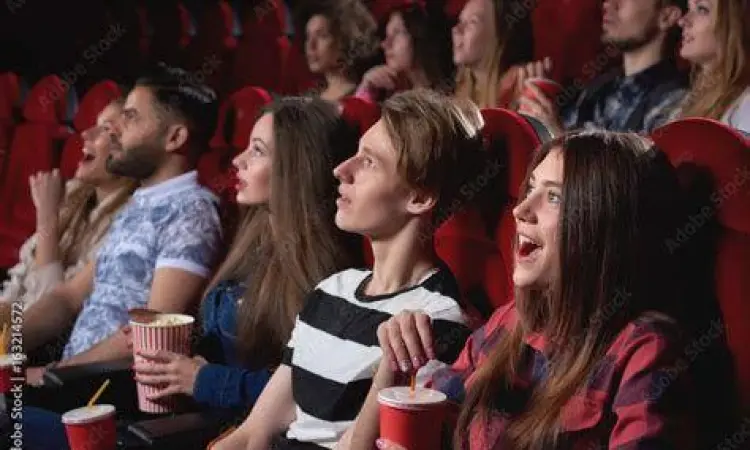 Penonton menikmati film di bioskop dengan teks terjemahan