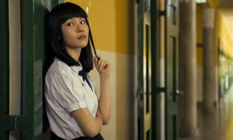 Nanno Girl From Nowhere Nanno tersenyum ikonik di depan sekolah